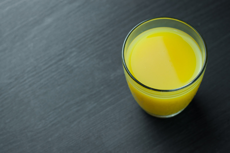 Close Up of orange juice in glass on wooden background.