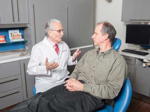 Dentist talking to a man in the dental clinic